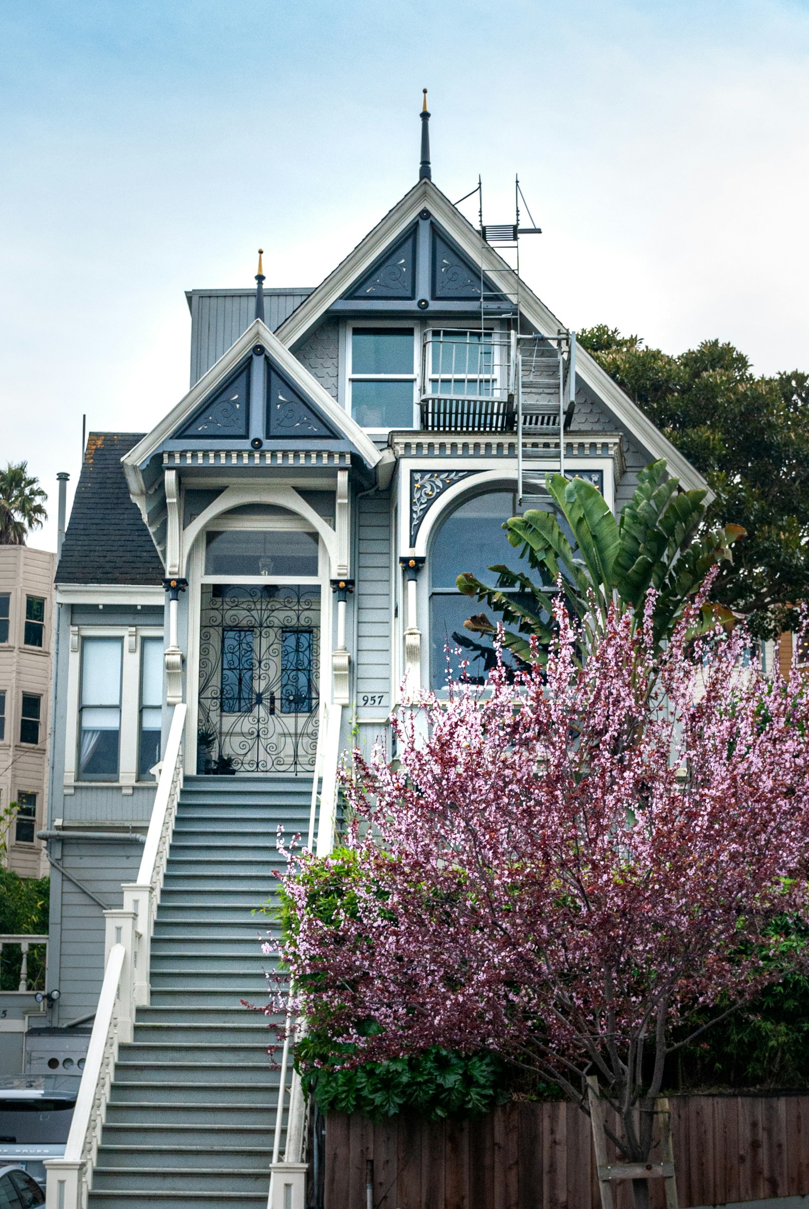 A classic San Francisco Victorian home with a grand staircase and blooming tree